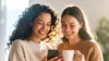 Zwei Frauen schauen gemeinsam auf ein Smartphone und lächeln
