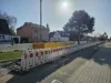 Die Baumaßnahme der GGEW in Bürstadt. Eine Absperrung entlang der Straße. Im Hintergrund Häuser und ein Baggerarm.