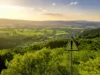 Blick über grüne Landschaft mit Schild Warnung im Vordergrund