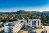 Modernes Unternehmensgebäude aus der Vogelperspektive mit grüner Stadt im Hintergrund