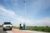 3 GGEW Mitarbeiter stehen unter einer LED Straßenlaterne