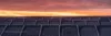 Das Bild einer Photovoltaik-Anlage bei Sonnenuntergang