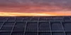 Das Bild einer Photovoltaik-Anlage bei Sonnenuntergang
