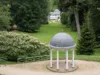 Pavillon mit einer Kuppel und sechs weißen Säulen, der in einer parkähnlichen Umgebung steht
