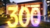 Modernes kleines Haus, davor die leuchtende Zahl 300