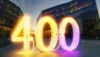 Beleuchtetest Bürogebäude, davor die leuchtende Zahl 400