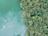 Drohnenaufnahme von einem türkisblauen See und grünen Bäumen